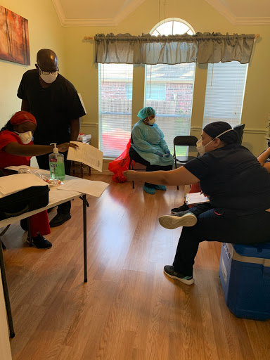 A healthcare setting where patients are receiving vaccinations with staff members observing safety protocols.