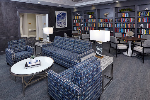 A modern living room featuring a stylish sofa, coffee table, and bookshelves filled with books.