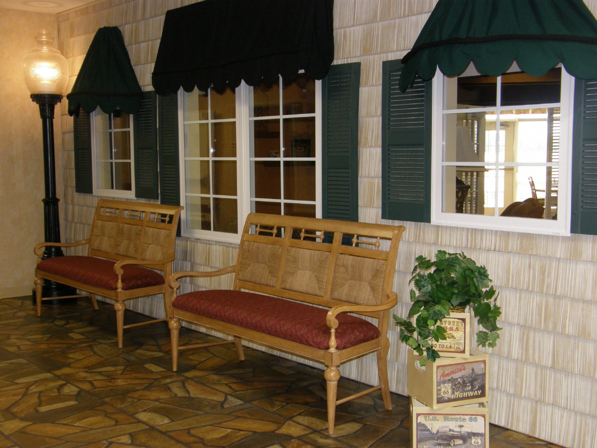 An indoor seating area with benches, windows, and green awnings.