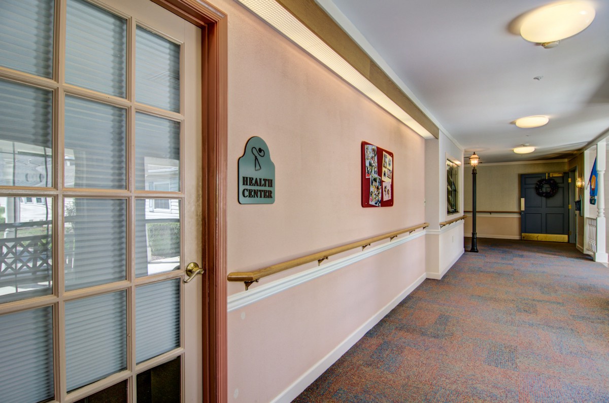 A corridor with a door and wall decorations, featuring informational signage.