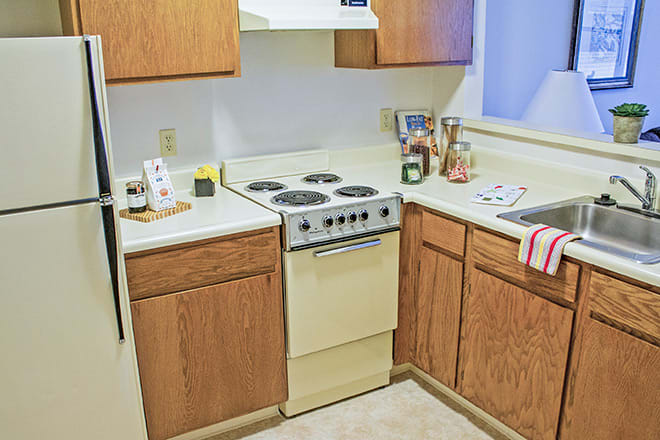 A small kitchen with wooden cabinets and an electric stove.