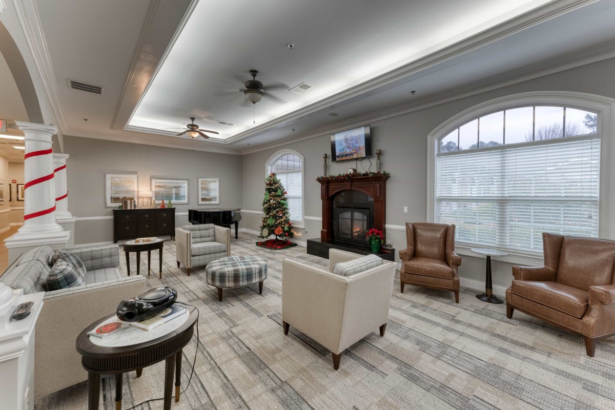 A spacious living room with modern decor, featuring a fireplace and a Christmas tree.