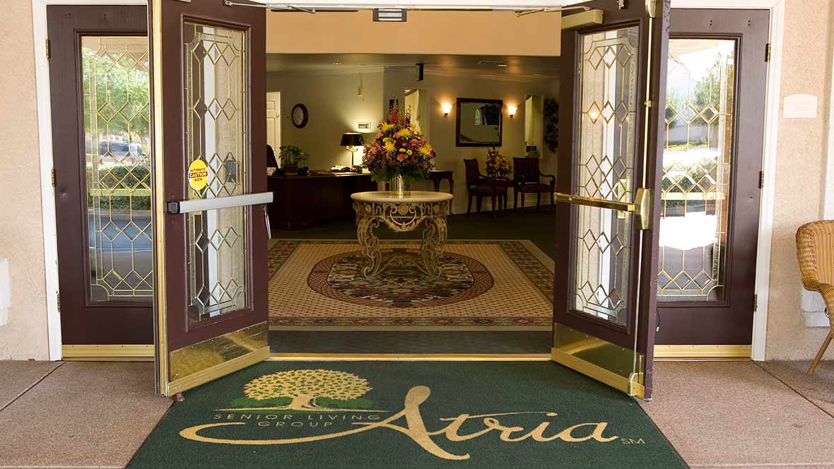 Entrance to a building with a welcoming lobby and a decorative mat.
