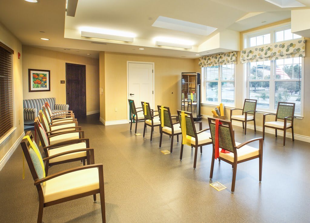 A spacious waiting room with rows of chairs and bright lighting.
