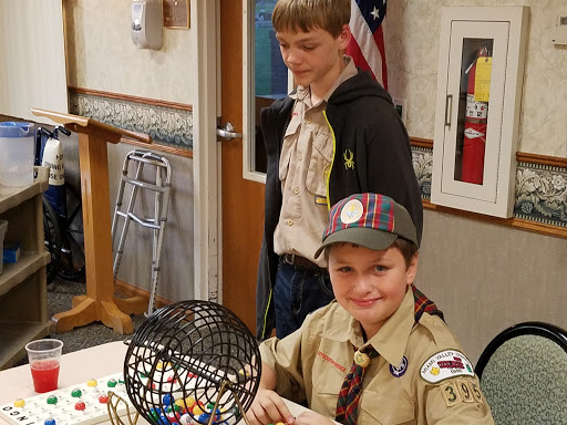 Two boys in scout uniforms enjoying a game of bingo.