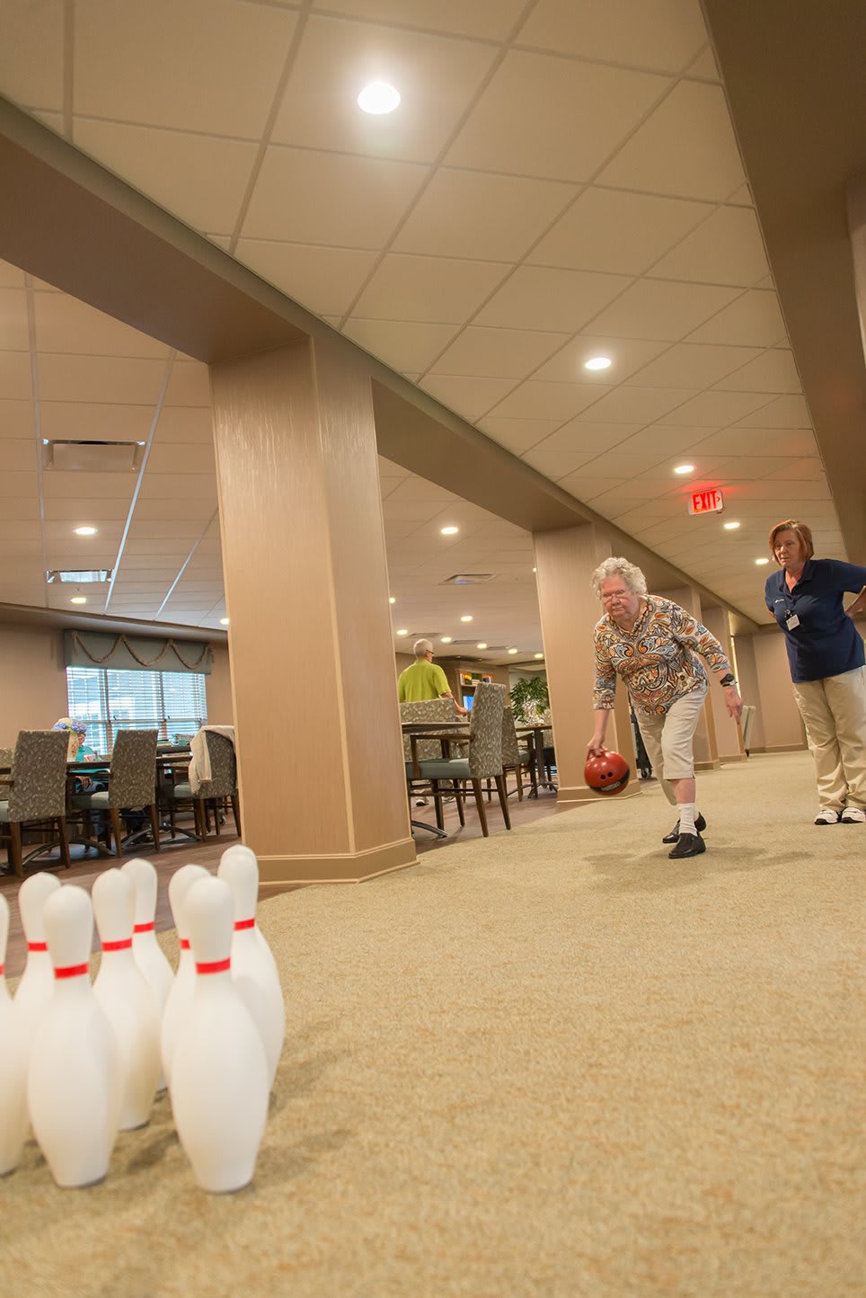 Seniors enjoying a game of indoor bowling, showcasing leisure and recreation.