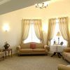 A classic living room with sofas, elegant curtains, and a lamp.
