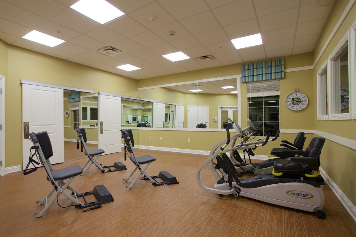 A modern gym with exercise bikes and mirrored walls.
