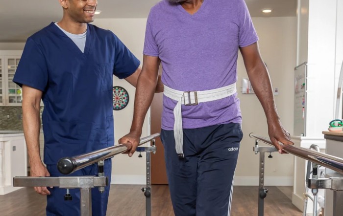 A healthcare professional assists a patient during physical therapy.