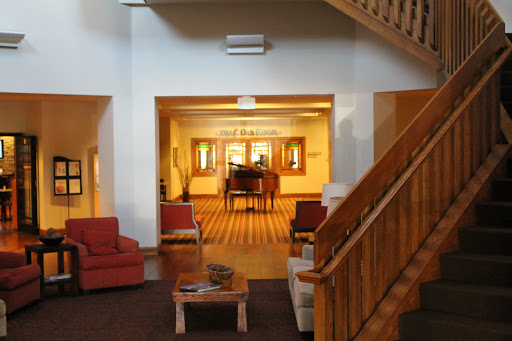 A cozy lobby area featuring a wooden staircase and comfortable seating.