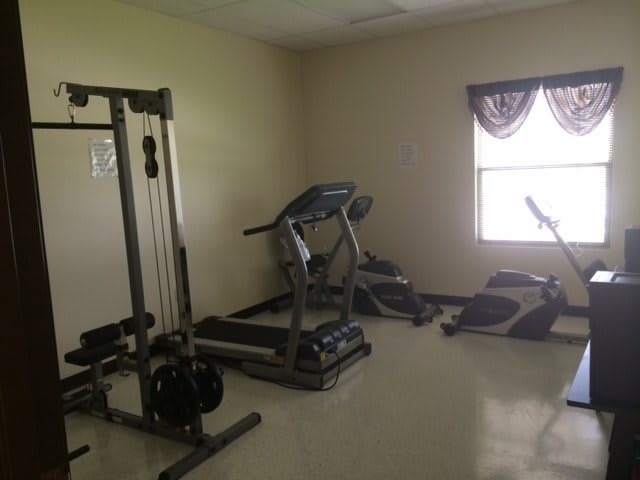 A small home gym with exercise equipment including a treadmill and weight machine.