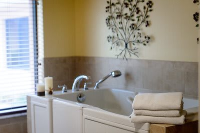 A cozy bathroom with a bathtub, neatly folded towels, and decorative candles.