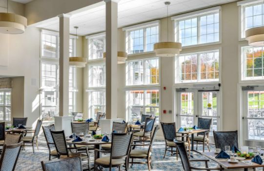 A modern dining area with large windows allowing natural light to fill the room.