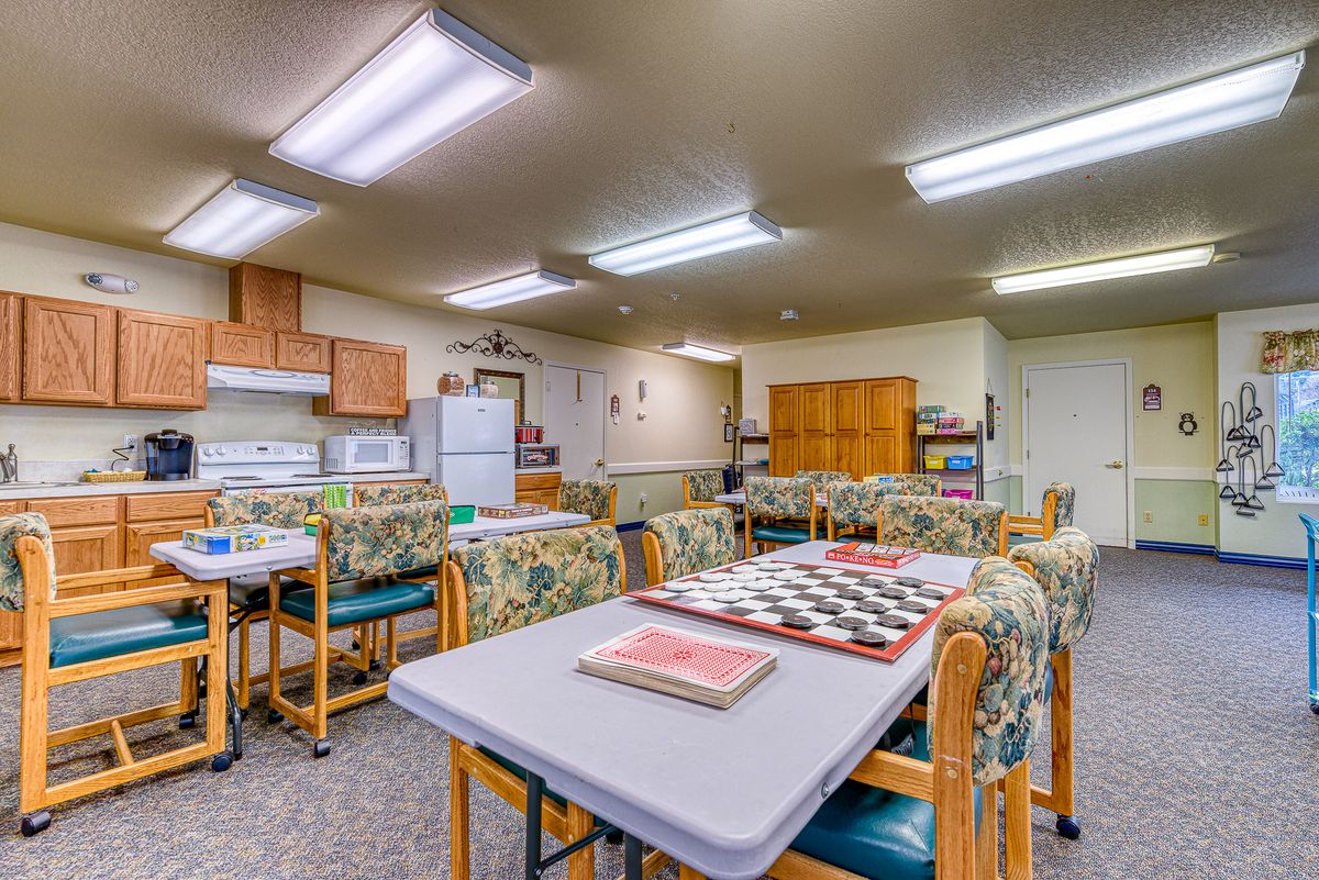 A spacious indoor kitchen and dining area with tables, chairs, and appliances.