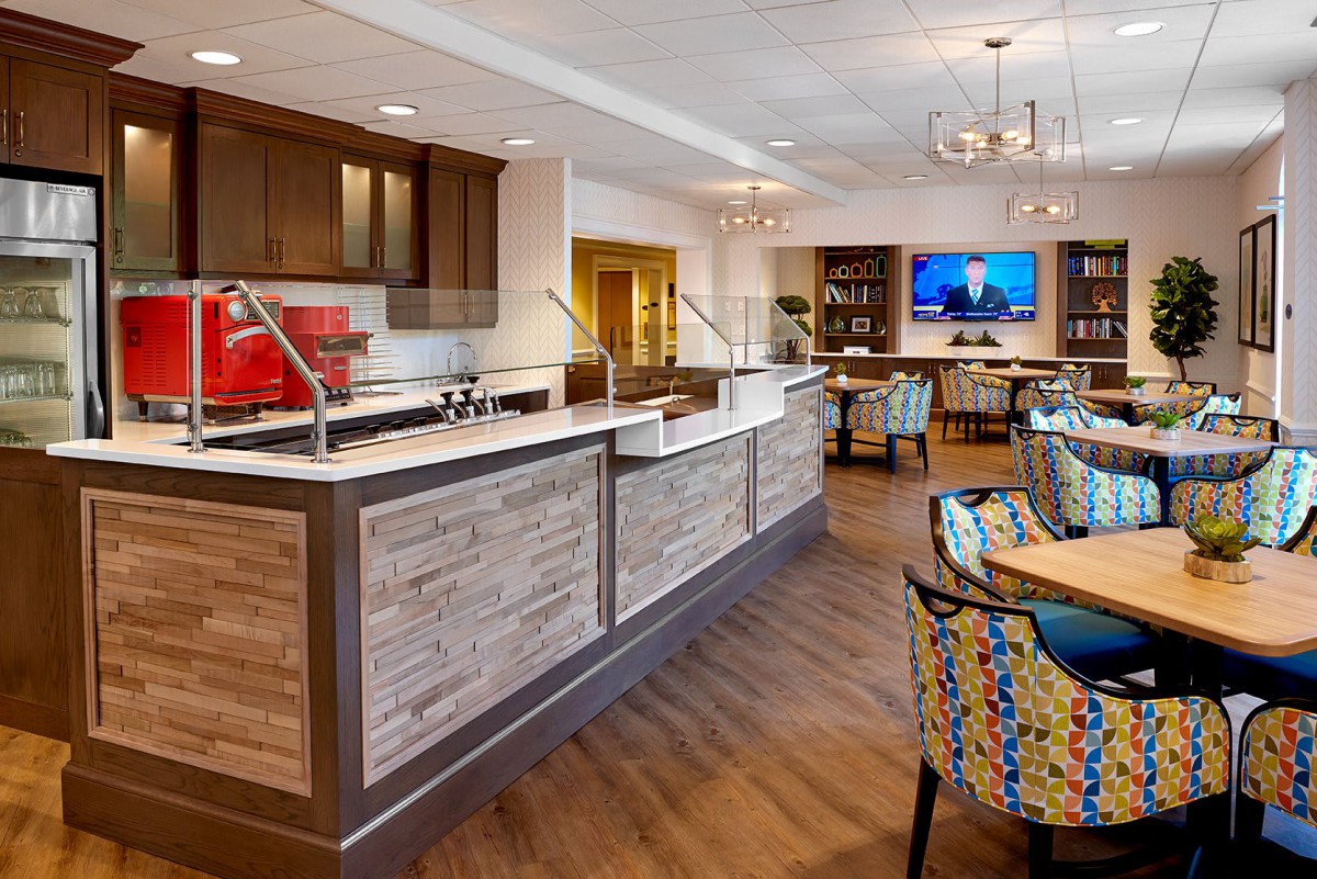 A modern kitchen and dining area with wooden flooring and stylish seating.