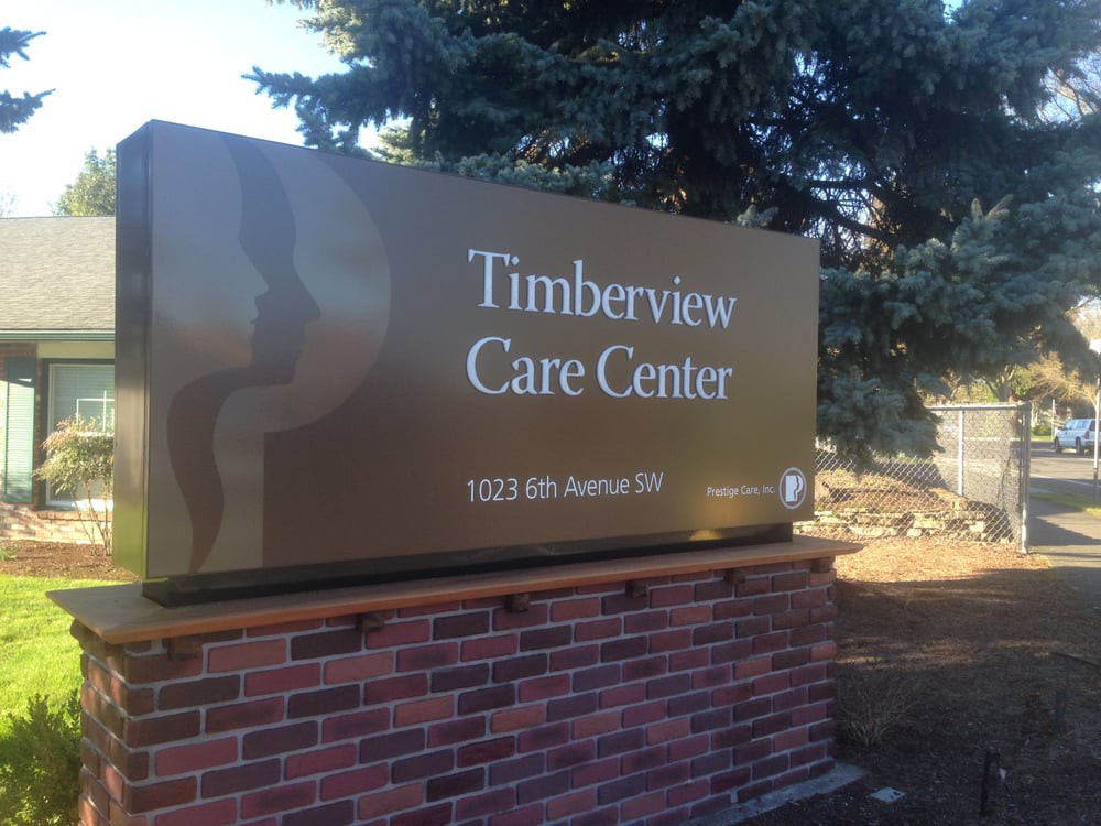 A sign for Timberview Care Center with a brick base outdoors.