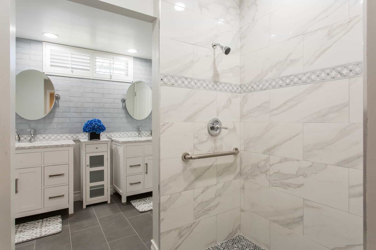 A modern bathroom featuring a marble-tiled shower and sleek vanity.