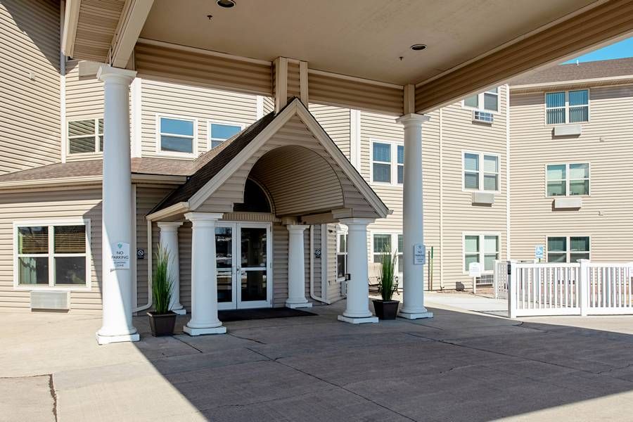 The entrance of a hotel featuring columns and a covered walkway.