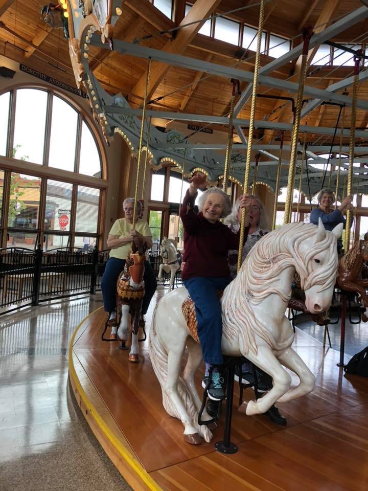People enjoying a ride on a carousel indoors.