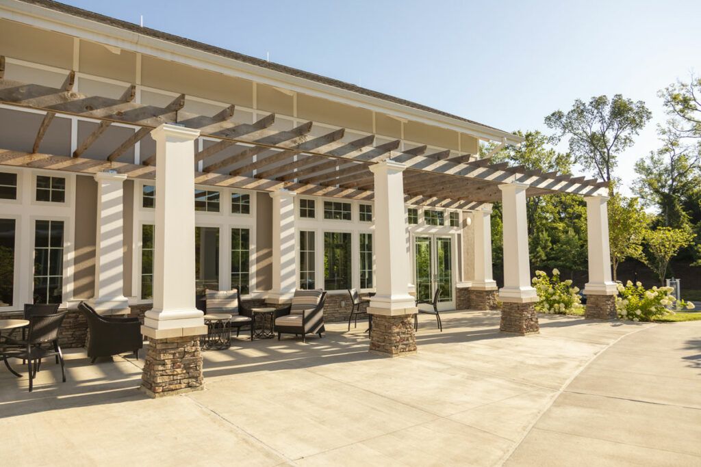 A sunny outdoor patio featuring a pergola and comfortable seating area.