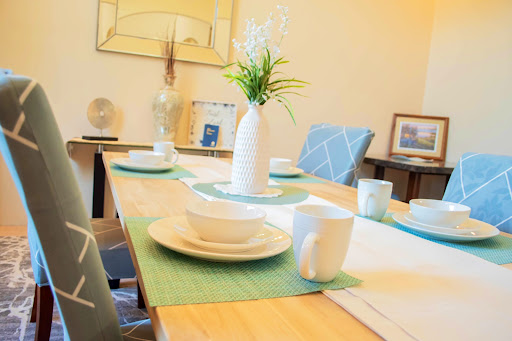 A beautifully set dining table with minimalist decor and a fresh flower centerpiece.