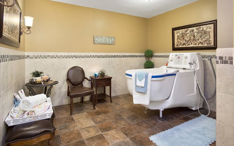 A well-decorated bathroom featuring a white bathtub, elegant chair, and stylish decor.