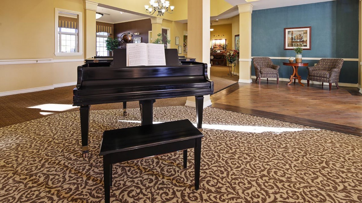 A grand piano in a well-decorated lobby space with elegant furnishings.