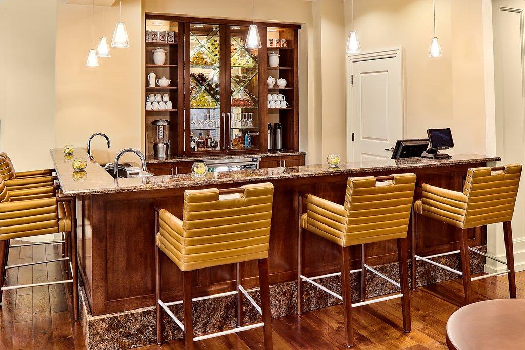 A cozy and elegant bar area with wooden stools and ambient lighting.