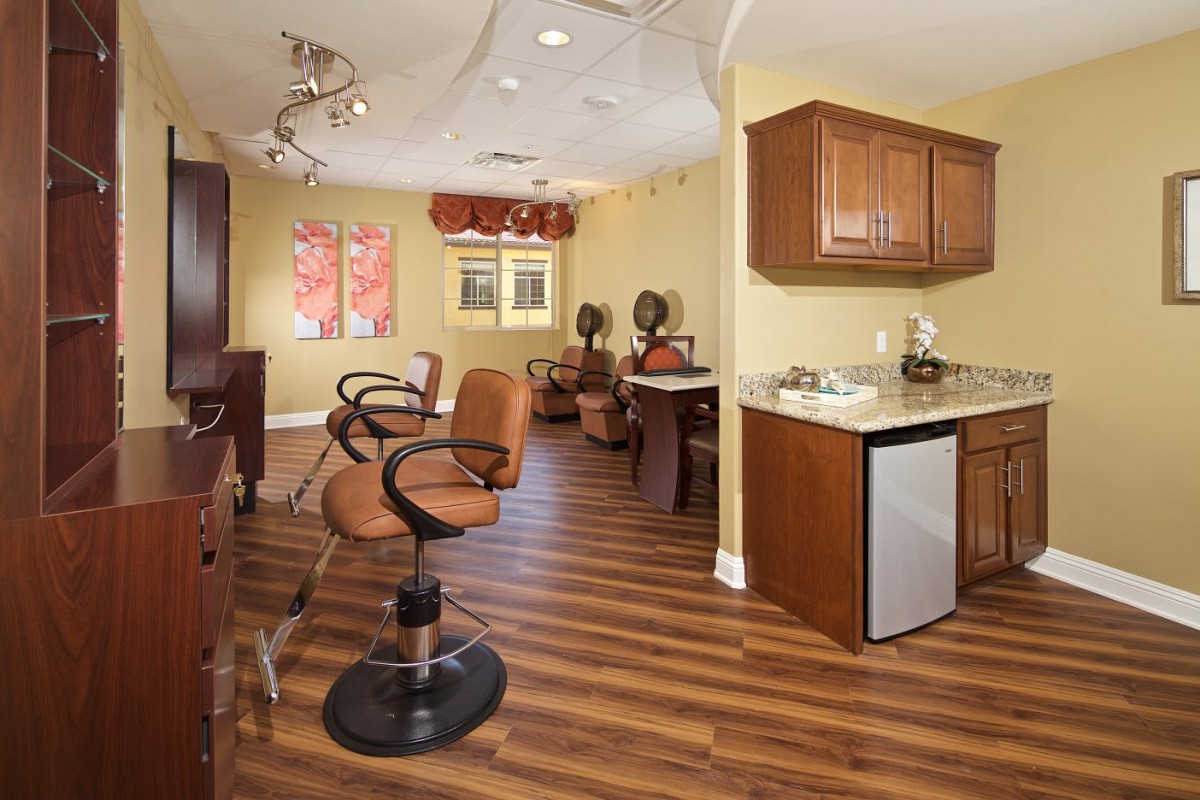 Interior of a modern salon with styling stations and wooden flooring.