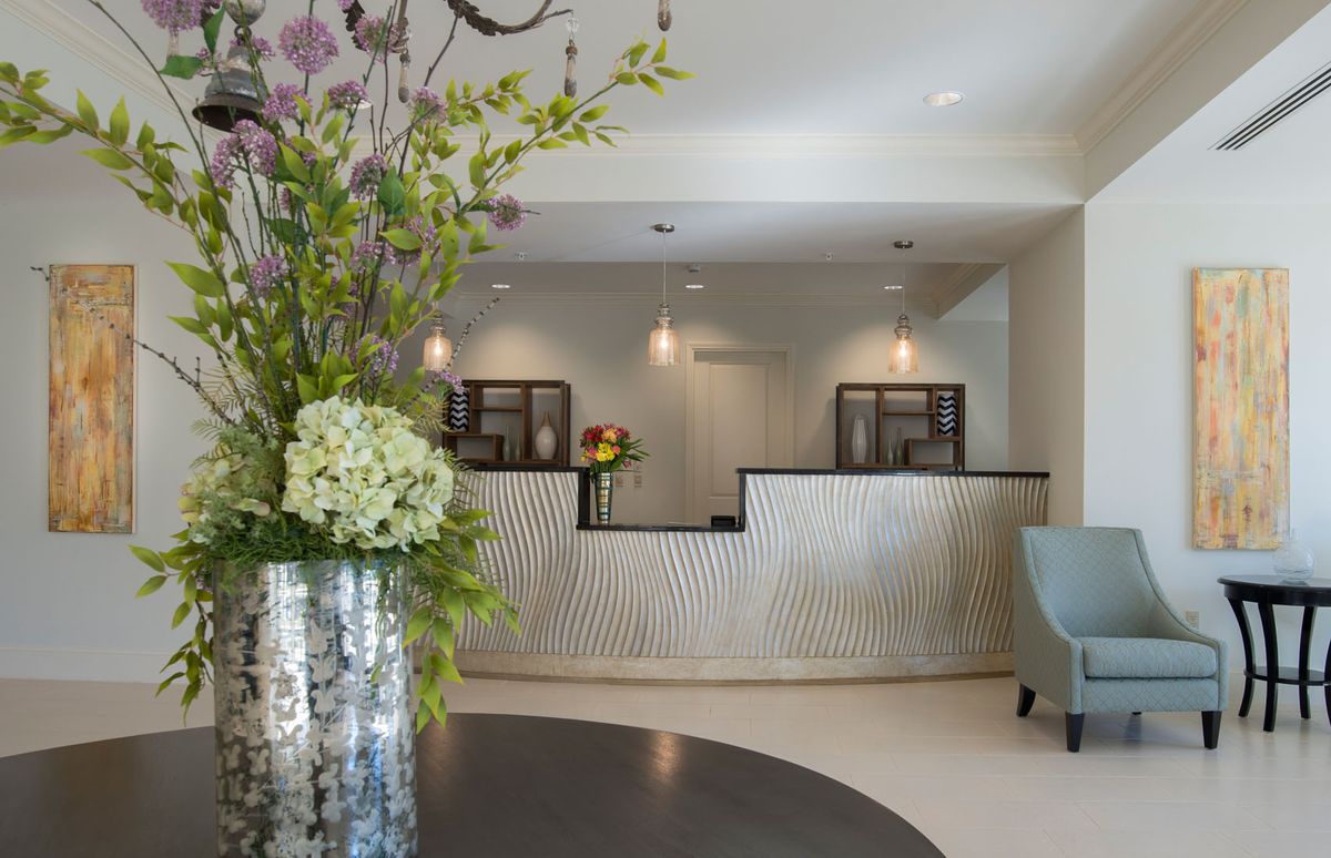 Stylish hotel lobby with elegant floral arrangements and a modern front desk.