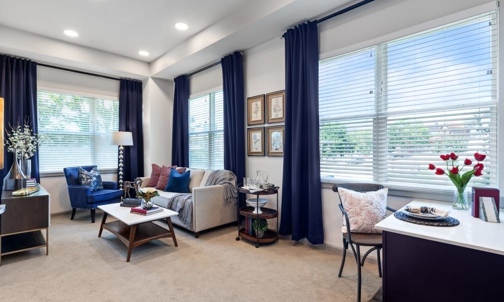 A modern living room featuring blue curtains, a comfortable sofa, and a stylish coffee table.