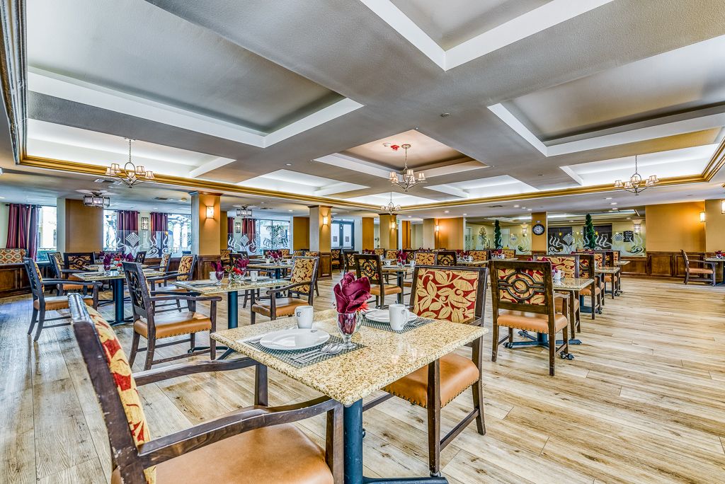 A spacious and elegantly designed restaurant interior with neatly arranged tables and chairs.