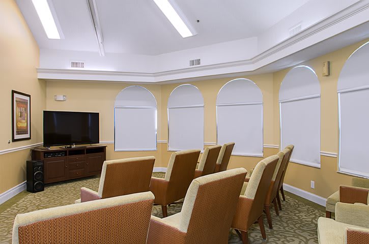 A cozy theater room with comfortable seating and a large television.