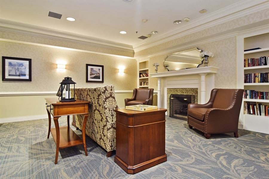 A cozy, traditionally decorated living room with seating and a fireplace.