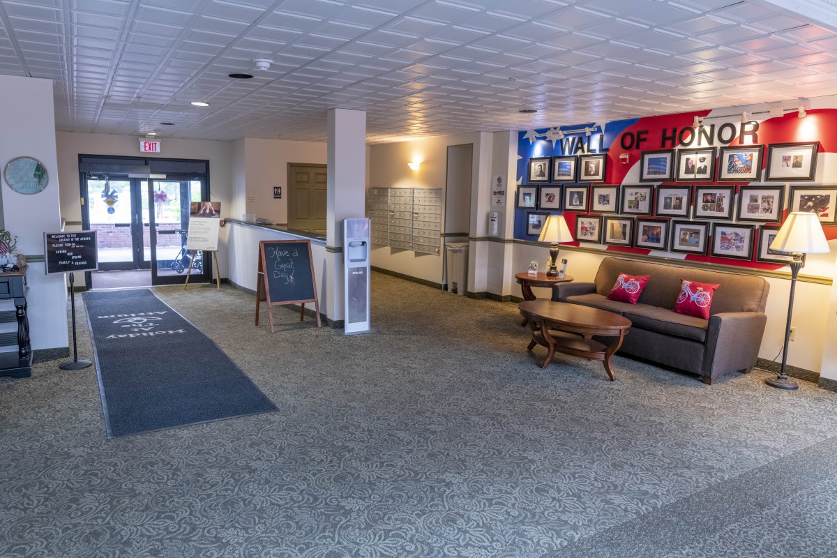 A welcoming lobby with comfortable seating and a display of framed pictures on the wall.