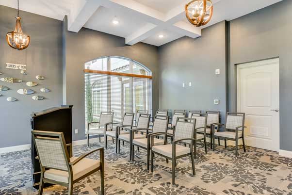 A modern conference room setup with chairs arranged in rows, featuring large windows and elegant lighting.