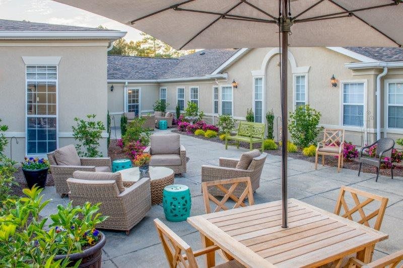 A cozy outdoor patio area with seating and greenery.