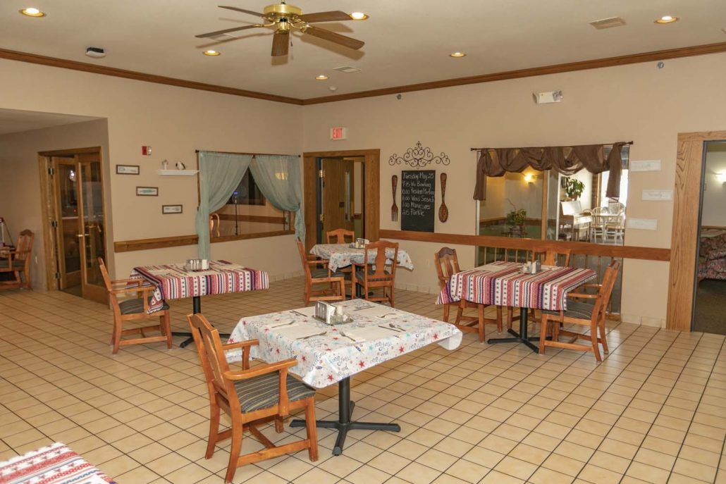 Cozy dining area with tables and chairs arranged neatly, featuring a warm and inviting interior decor.