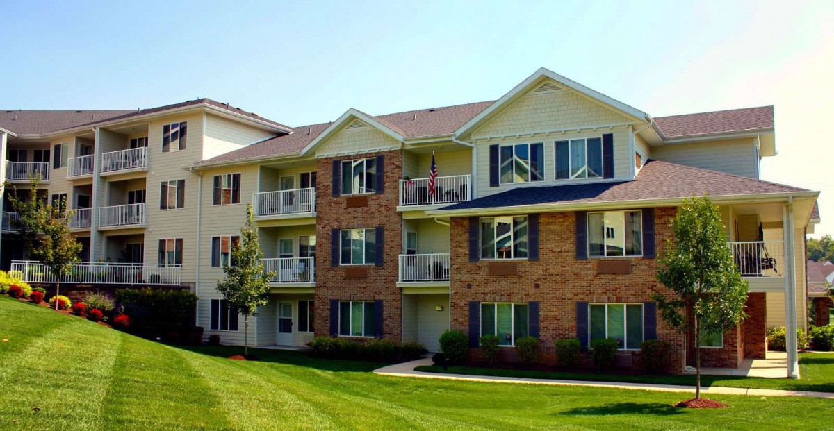 A modern suburban apartment building with balconies and well-maintained landscaping.