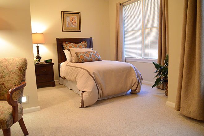 A cozy bedroom with a neatly made bed, soft lighting, and elegant decor.
