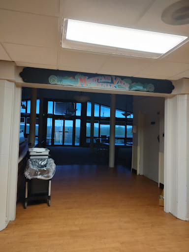 An entrance to a hospital reception area with large windows and clear signage.