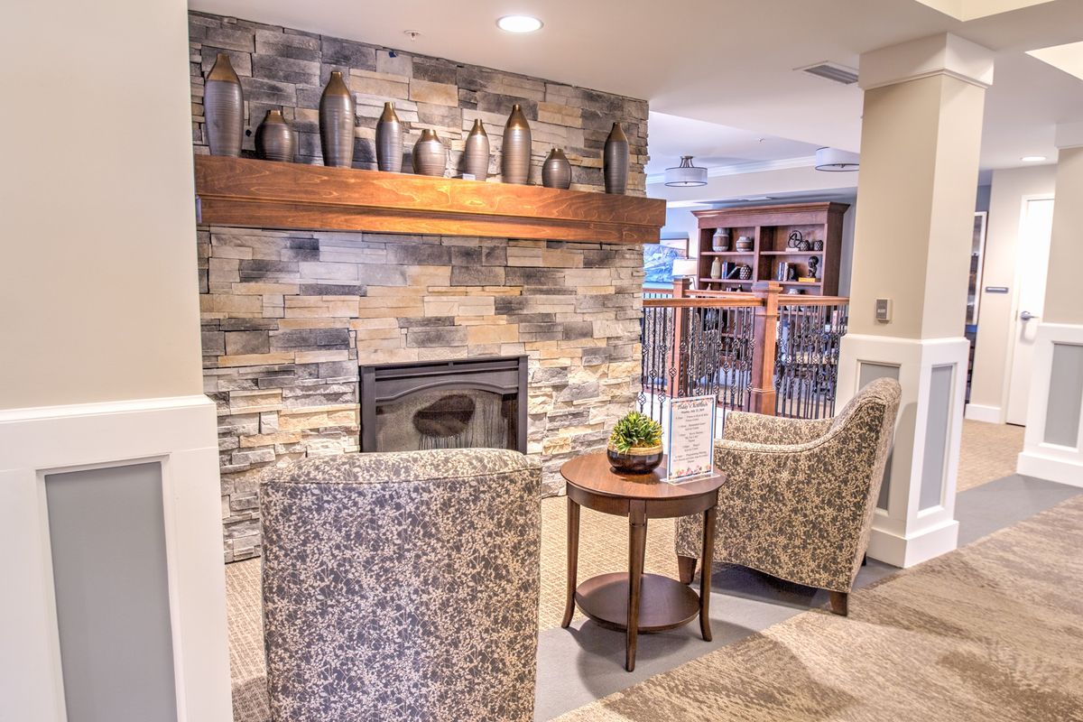 A cozy living room featuring a stone fireplace, comfortable armchairs, and stylish decor.