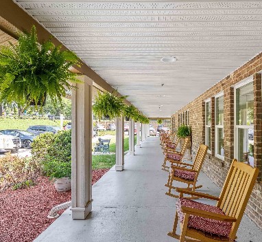 A serene porch with rocking chairs and hanging plants.