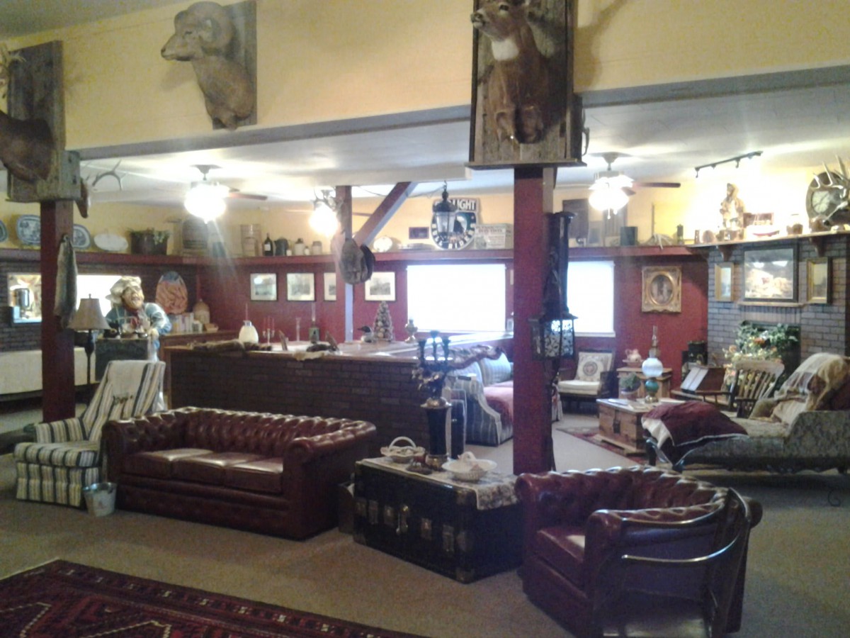 A rustic lounge area featuring leather sofas and wooden decor.