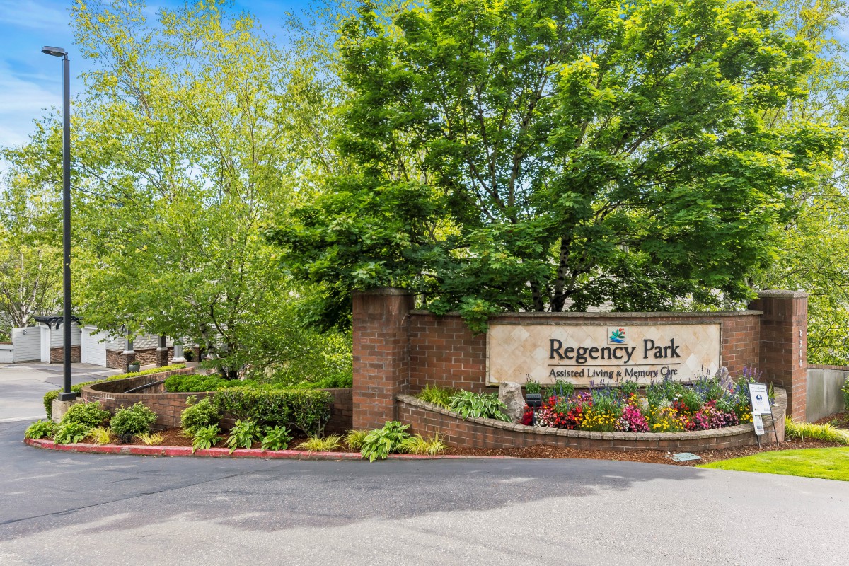 Entrance to Regency Park surrounded by lush landscaping and trees.
