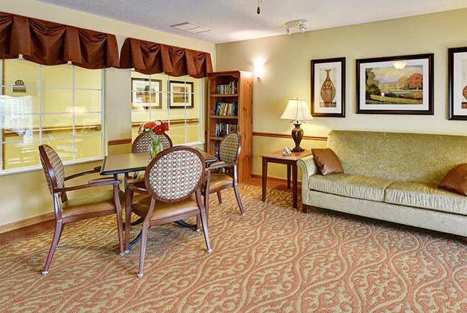 A cozy living room with a sofa, table, chairs, and warm lighting.
