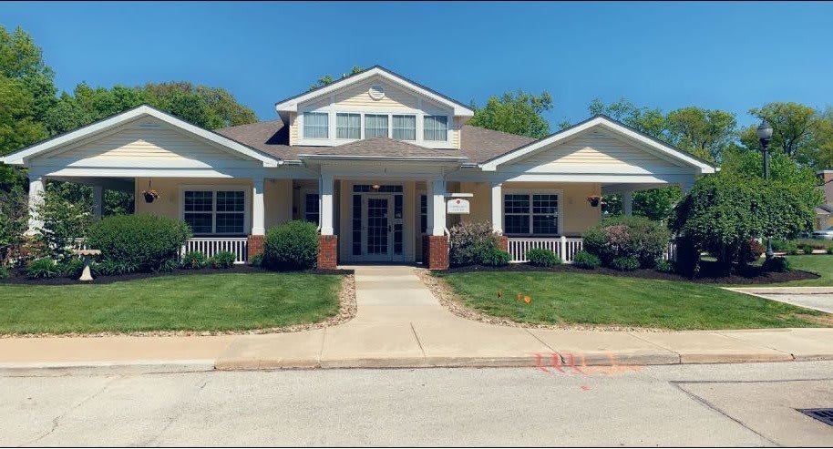 A suburban house with a well-maintained front lawn on a sunny day.