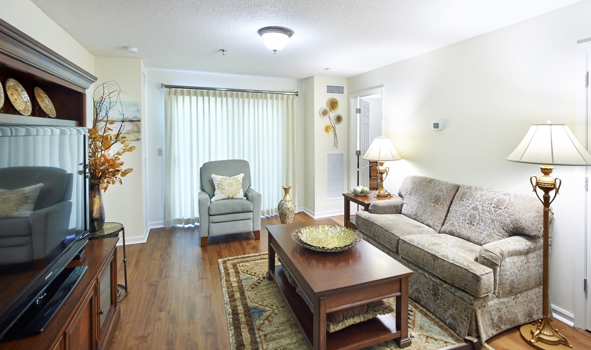 A cozy living room featuring a sofa, armchair, and coffee table, complemented by a rug and tasteful decor.