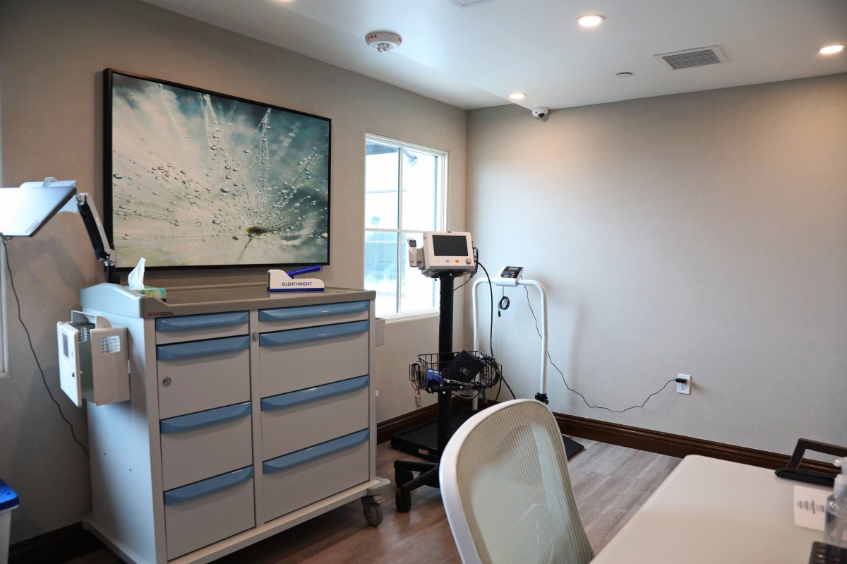 A clean and modern medical examination room equipped with various medical devices.