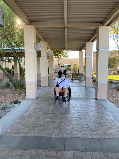 Two friends enjoying a walk together, with one in a wheelchair.